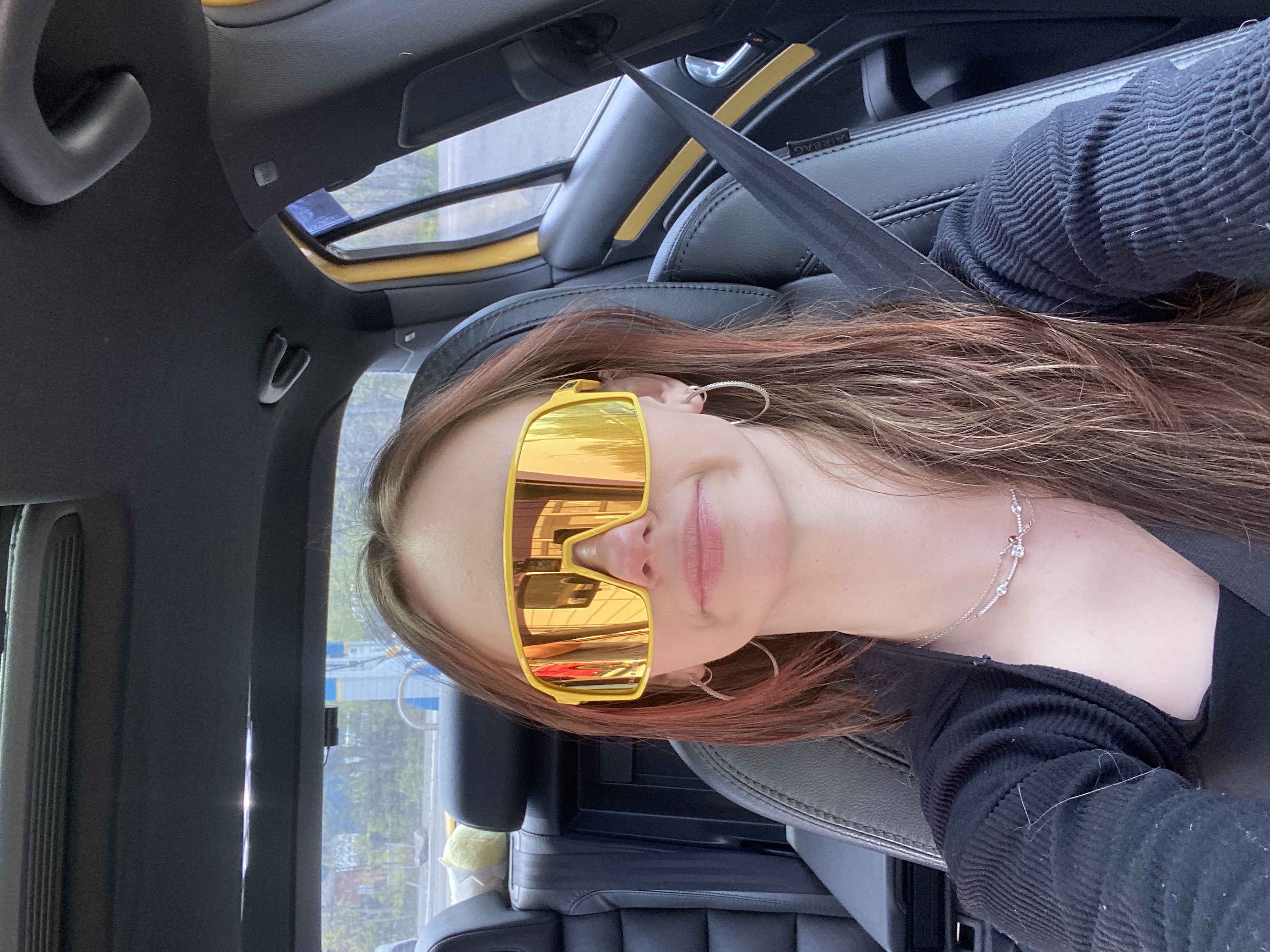 Abby in the car wearing yellow sunglasses