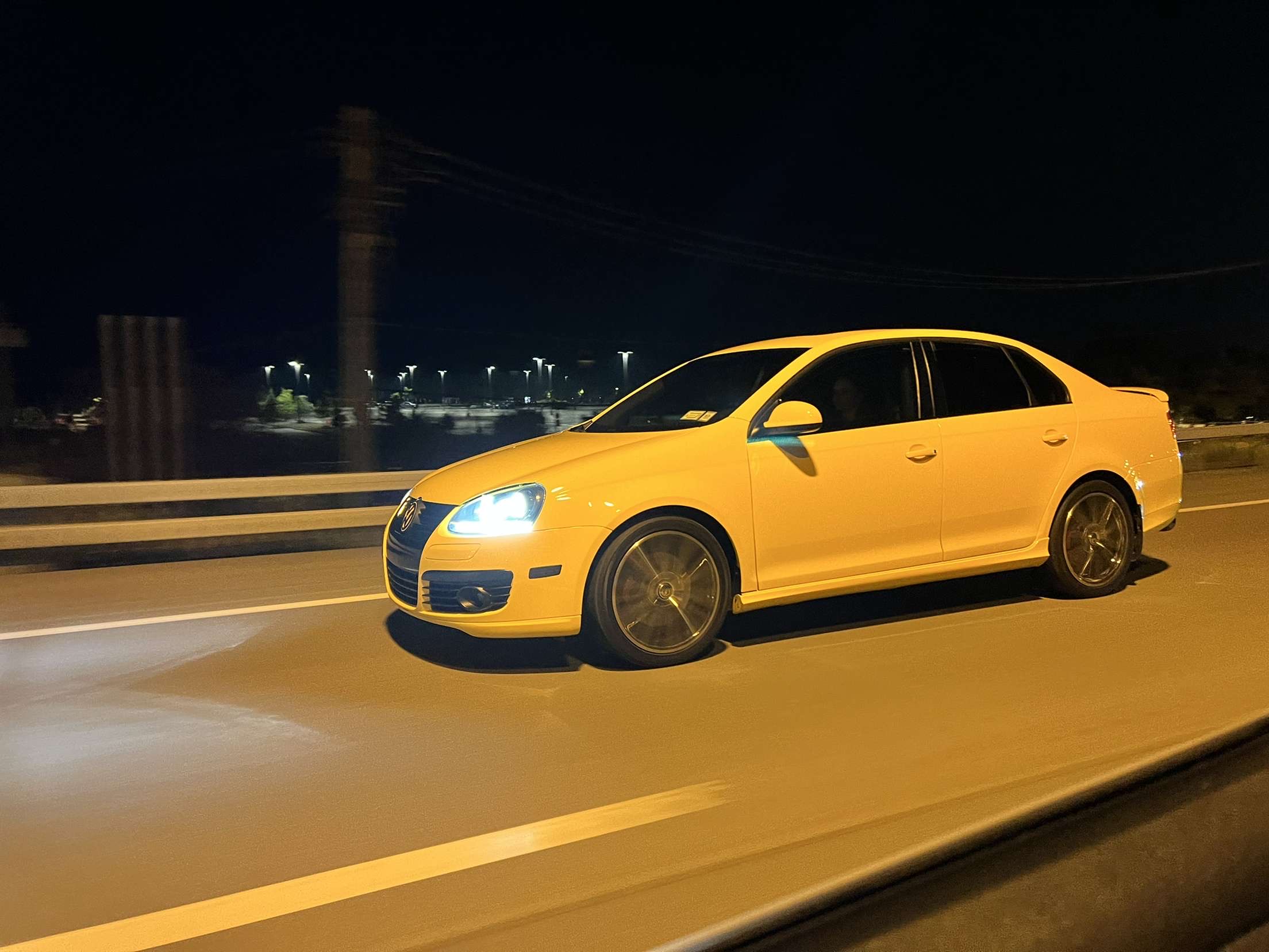 Abby's yellow Volkswagen GLI driving at night