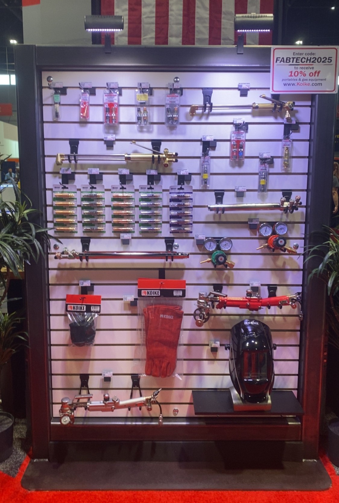 Koike gas application display wall at Fabtech with torches, regulators, cutting tips, and gloves