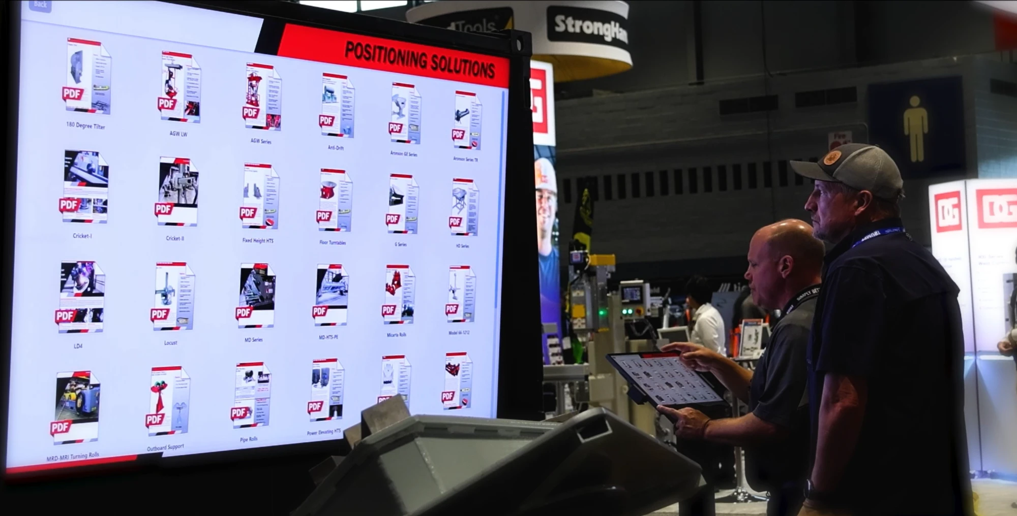 A Koike sales representative using the tablet to browse the Positioning Solutions display at Fabtech